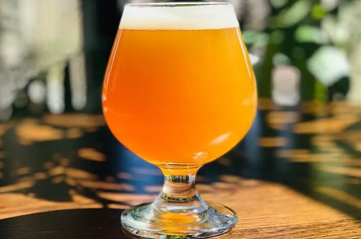 Hazy beer in a tulip glass on a sunlit patio table
